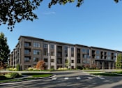 Thumbnail 3 of 4 - A large apartment complex with a parking lot in front.