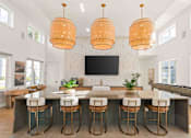 Thumbnail 25 of 61 - A kitchen with a bar area and a television mounted on the wall at Verity Luxury Apartments, Florida 32960