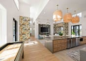Thumbnail 10 of 61 - A modern kitchen with a pool table in the middle at Verity Luxury Apartments, Florida