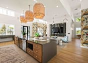 Thumbnail 8 of 61 - A modern kitchen with a large island and wooden floors at Verity Luxury Apartments, Vero Beach, Florida