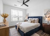 Thumbnail 55 of 61 - A bedroom with a large bed and a ceiling fan at Verity Luxury Apartments, Vero Beach, 32960