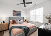 Thumbnail 4 of 61 - A bedroom with a bed, a ceiling fan, and a painting on the wall at Verity Luxury Apartments, Vero Beach, Florida