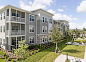 Thumbnail 32 of 61 - A large apartment complex with a well-maintained lawn and landscaping at Verity Luxury Apartments, Florida 32960