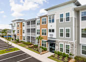Thumbnail 3 of 61 - A row of modern apartment buildings with a parking lot in front at Verity Luxury Apartments, Florida