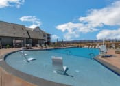 Thumbnail 3 of 38 - a large swimming pool with lounge chairs and a building in the background  at Upland Flats, Colorado, 80922