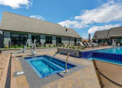 Thumbnail 29 of 38 - a resort style pool and hot tub with lounge chairs and a building in the background  at Upland Flats, Colorado Springs, CO