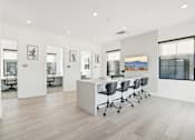 Thumbnail 26 of 108 - a white office with a large desk and chairs at The Maddox Luxury Apartment Homes, Buckeye, AZ 85326  