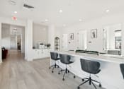 Thumbnail 42 of 108 - a white office with a long counter and chairs at The Maddox Luxury Apartment Homes, Buckeye  