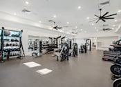 Thumbnail 39 of 108 - a gym with a lot of weights and exercise equipment at The Maddox Luxury Apartment Homes, Buckeye, AZ 85326  