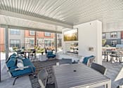 Thumbnail 34 of 108 - a living room with blue couches and chairs and a table at The Maddox Luxury Apartment Homes, Buckeye, 85326  