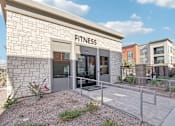 Thumbnail 37 of 108 - a fitness building with a glass door and a sign on the side of it at The Maddox Luxury Apartment Homes, Arizona  