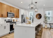 Thumbnail 2 of 58 - an open kitchen with a large white island with a counter top at Meridian at CityPlace, Woodbury