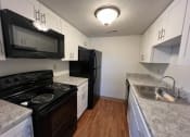 Thumbnail 2 of 15 - a kitchen with a stove a sink and a microwave at Holiday Park Apartments, Pittsburgh, PA