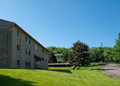 Thumbnail 16 of 16 - A large building with a green lawn in front of it.