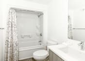 Thumbnail 37 of 38 - A white bathroom with a toilet, sink, and bathtub.