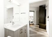 Thumbnail 38 of 38 - A bathroom with a sink, mirror, and a wooden cabinet.