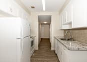 Thumbnail 1 of 40 - A kitchen with white appliances and cabinets.