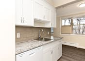 Thumbnail 5 of 40 - A kitchen with white cabinets and a marble countertop.