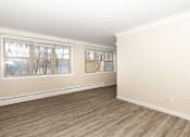 Thumbnail 11 of 40 - A room with wooden flooring and two windows.