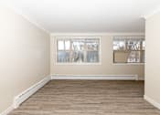 Thumbnail 12 of 40 - A room with a window and wooden flooring.