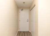 Thumbnail 19 of 40 - A white door is in the middle of a hallway.