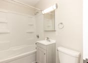 Thumbnail 22 of 40 - A white bathroom with a tub, sink, and toilet.