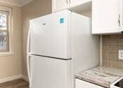 Thumbnail 7 of 40 - A white fridge in a kitchen with a window.