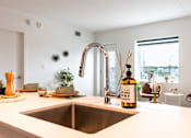 Thumbnail 12 of 36 - A modern kitchen with a stainless steel sink and a copper faucet.
