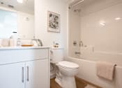 Thumbnail 22 of 36 - A white bathroom with a toilet, sink, and bathtub.