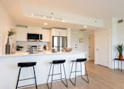 Thumbnail 7 of 47 - A kitchen with white cabinets and black bar stools.