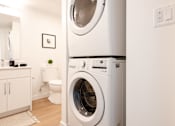 Thumbnail 45 of 47 - A white washing machine in a laundry room.
