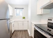 Thumbnail 18 of 33 - a white kitchen with stainless steel appliances and white cabinets