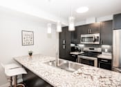 Thumbnail 11 of 25 - an expansive kitchen with granite countertops and stainless steel appliances
