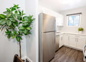 Thumbnail 15 of 33 - a kitchen with white cabinets and a stainless steel refrigerator