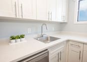 Thumbnail 19 of 33 - a kitchen with white cabinets and a sink and a window