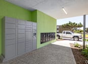 Thumbnail 6 of 15 - A parking garage with a green wall and a grey truck in the background.