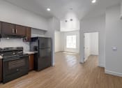 Thumbnail 10 of 15 - A kitchen with black appliances and wooden floors.