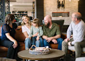 Thumbnail 73 of 74 - a family sits on a couch in a hotel lobby  at Harbor Heights 55+ Community, Washington