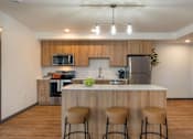 Thumbnail 1 of 20 - A kitchen with a bar stool in front of the counter at Elevation16 Apartments, Washington