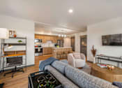 Thumbnail 16 of 20 - A modern living room with a grey sofa and a wooden coffee table at Elevation16 Apartments, Seattle, WA