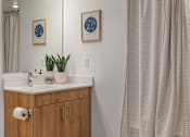 Thumbnail 20 of 20 - A bathroom with a wooden vanity and a shower curtain.