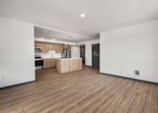Thumbnail 3 of 20 - an empty living room and kitchen with wood floors and white walls at Elevation16 Apartments, Washington