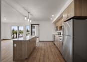 Thumbnail 5 of 20 - a large kitchen with wooden floors and stainless steel appliances at Elevation16 Apartments, Seattle, WA