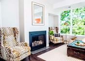 Thumbnail 3 of 68 - An elegant living room with luxurious stain-resistant plank flooring, a gas fireplace, and expansive windows that offer picturesque views of nature. A seamless transition to a balcony creates a spacious indoor-outdoor connection.
