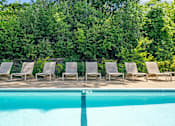 Thumbnail 23 of 28 - a group of lounge chairs next to a swimming pool