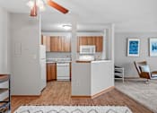 Thumbnail 8 of 28 - an open kitchen and living room with white appliances and wood flooring