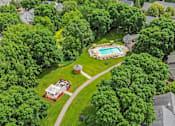 Thumbnail 37 of 41 - A bird's eye view of a house with a pool surrounded by trees.