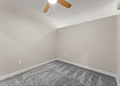Thumbnail 33 of 68 - A room with a ceiling fan and a carpeted floor.