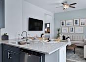 Thumbnail 2 of 23 - A modern kitchen with a grey countertop and a white sink.
