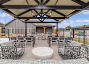Thumbnail 13 of 23 - A patio with a table and chairs under a canopy.